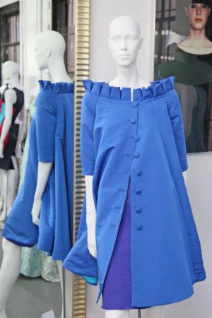 A mannequin wearing blue clothes in front of a mirror.